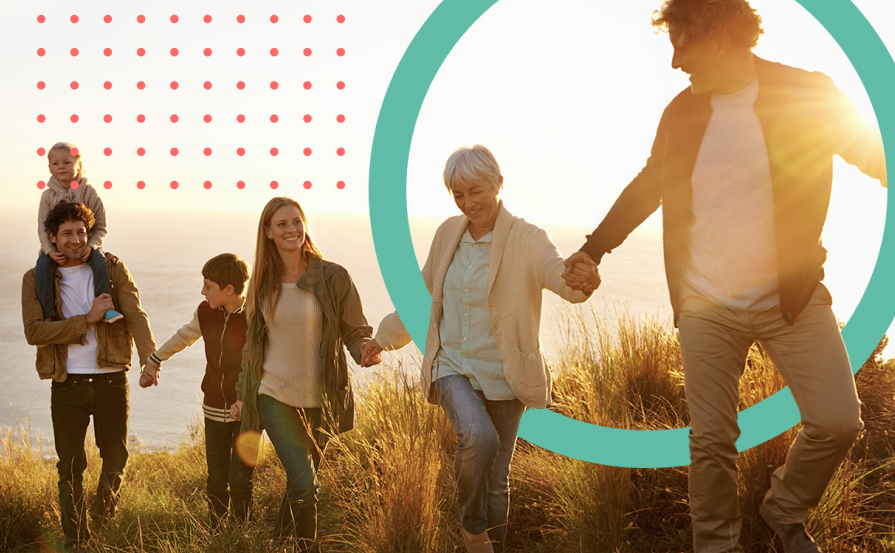 People walking through grass holding hands.